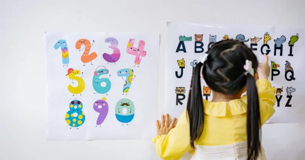 a child, kid learning english on the wall with alphabets